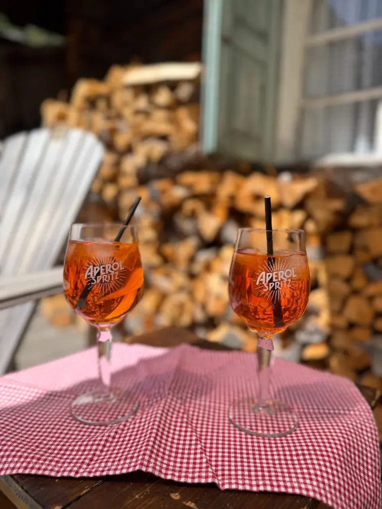 Zwei Aperol Spritz Gläser auf einer sonnigen Terrasse