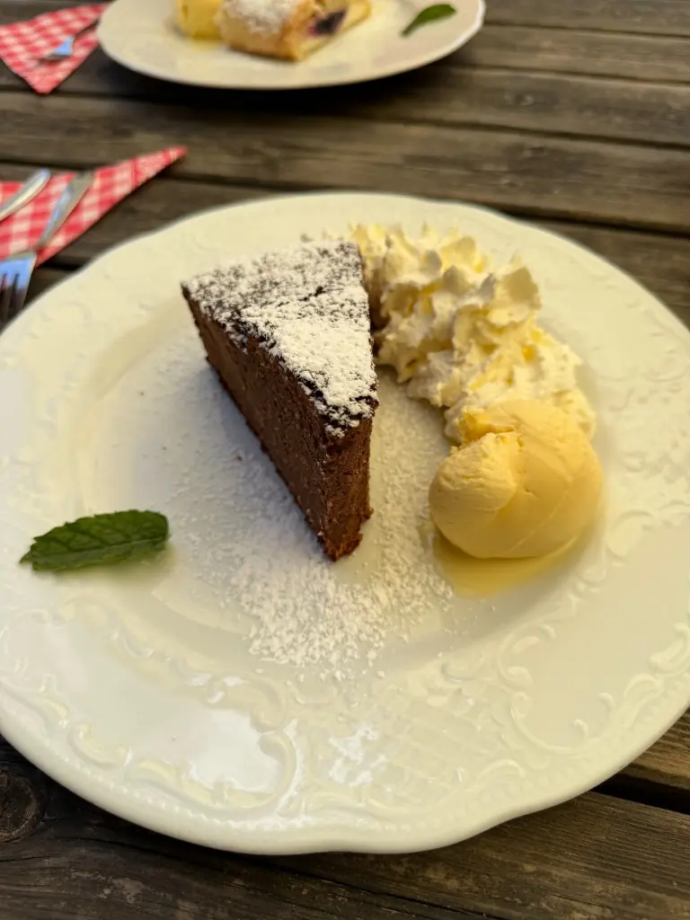 Ein Stück hausgemachter Schokoladenkuchen mit Schlagobers und Eis